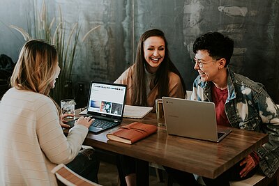 Group of happy young students in front of a laptop