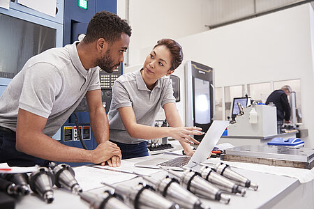 Two young engineers checking data on a computer