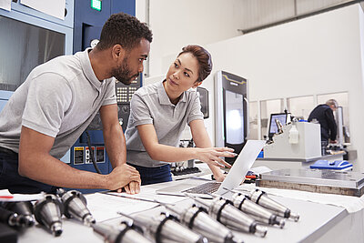 Two young engineers checking data on a computer