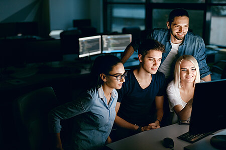 Group of young students sitting in front of a computer