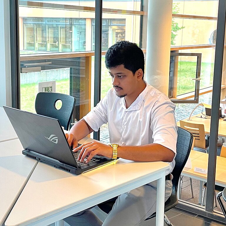 Saran studying in the library of Hof University