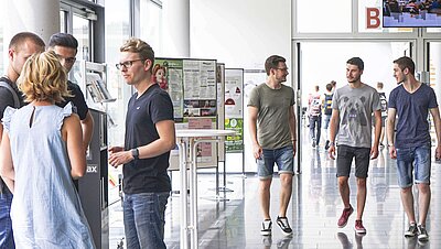 Studierende laufen durch das B-Foyer am Campus Hof