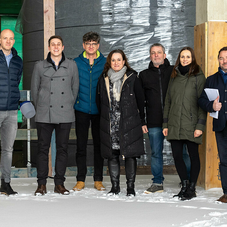 The project team in front of the central 150 m³ large heat storage tank