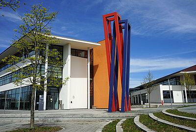 Hochschule Hof, Blick auf rot-blaue Säule und den Eingang des Gebäudes B