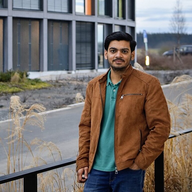 Aagam standing in front of the university dormitory